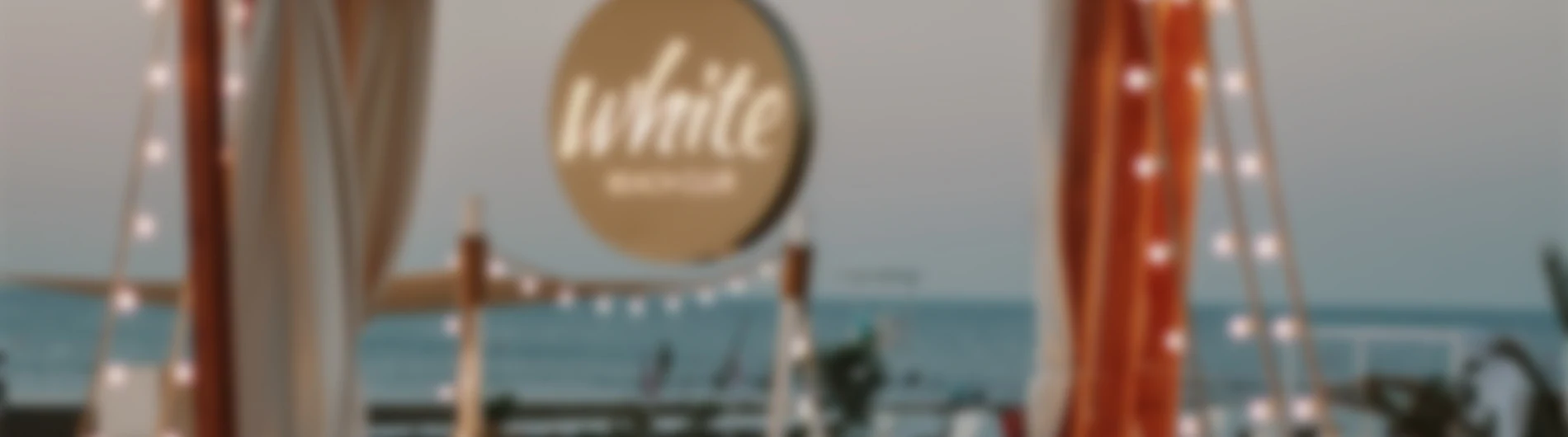 Alaqaranlıqda White Beach lövhəsi və girlyandlar