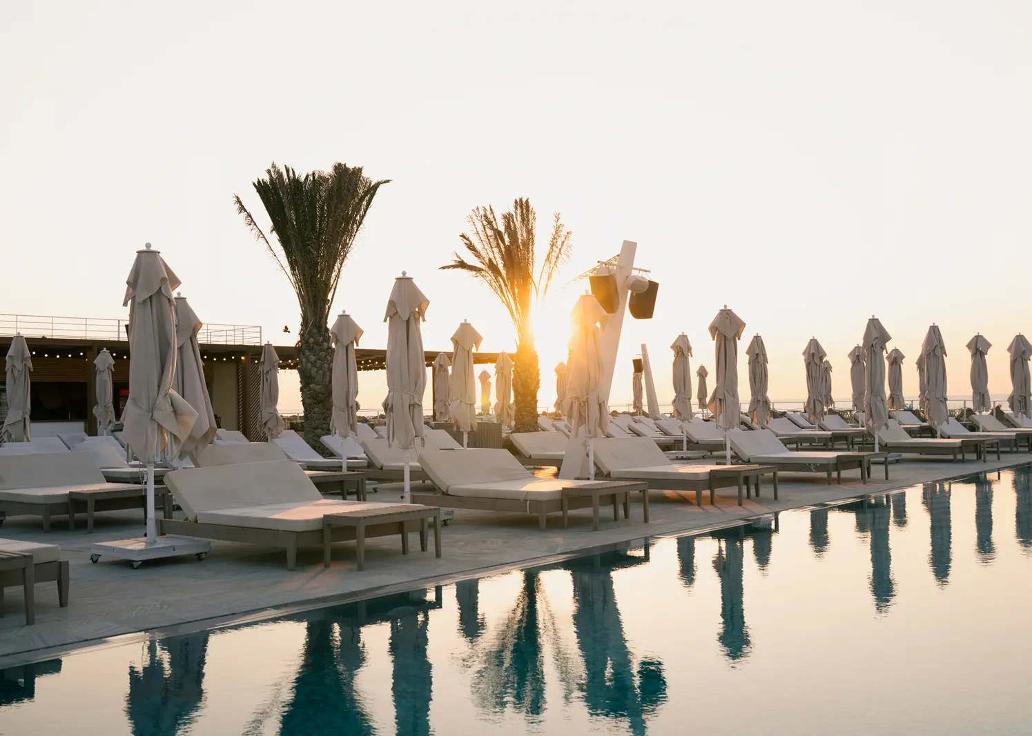 White Beach hovuzunun yanında çətirlərin arasından qürub